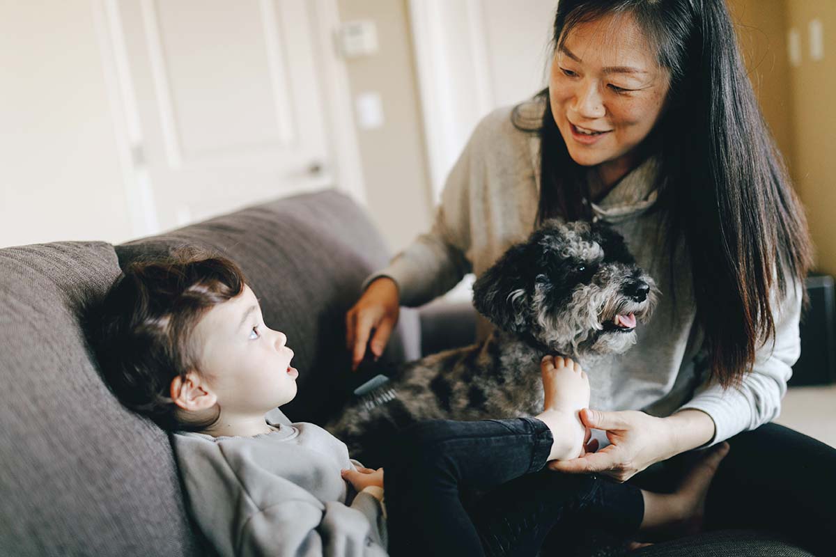 mother and child on couch with dog