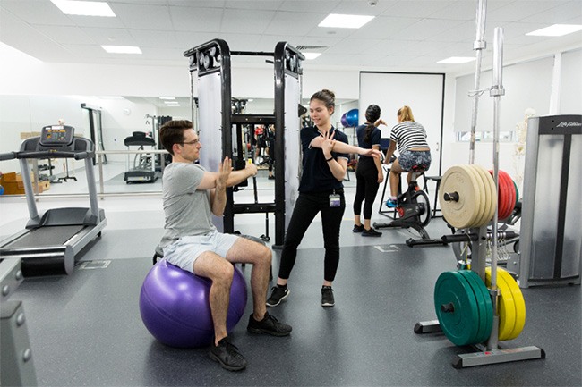 Student physiotherapist stretching with a patient.