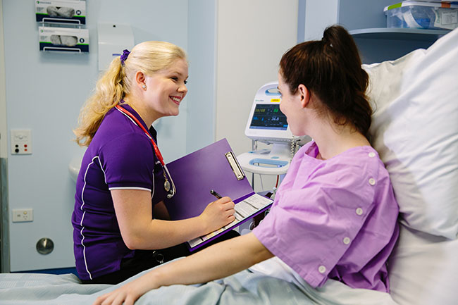 Nursing student on placement speaking with patient.