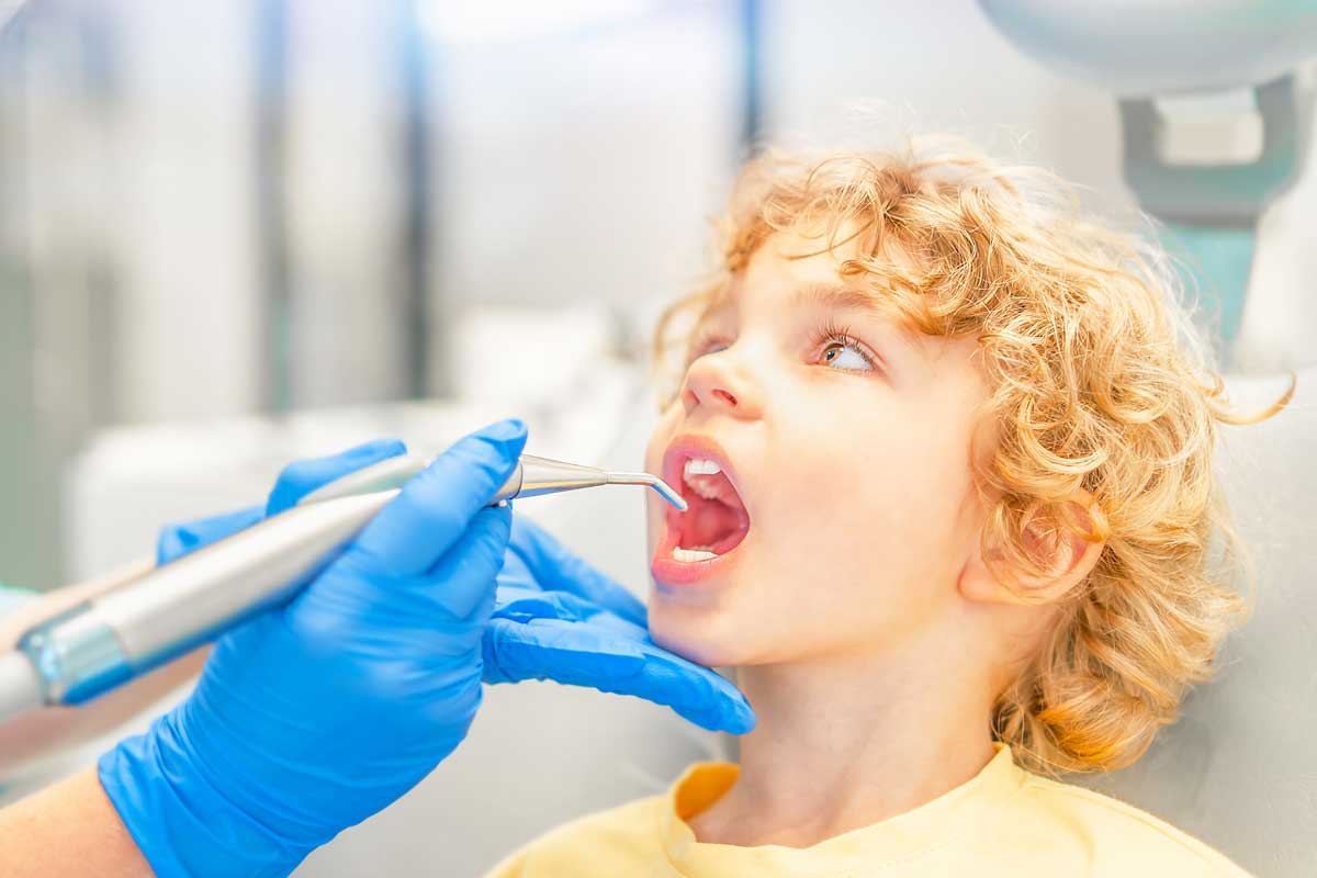 Child with dentist's gloved hands