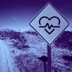 road sign on country road with heart beat icon