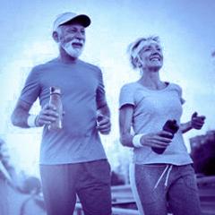 Elderly couple smiling and jogging