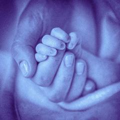 baby's hand clasping adult hand