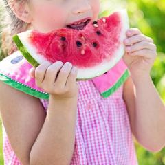 young girl eating a watermelon