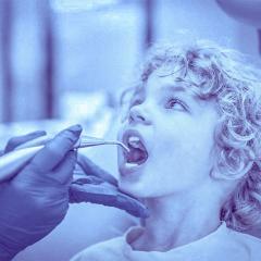 Child with dentist's gloved hands