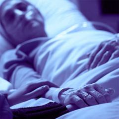 Dying patient holding hands with carer