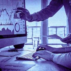 two people examining graphs on a computer