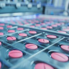 Pink pills during production and packing process on modern pharmaceutical factory.