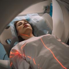 Woman laying in a medical imaging scanner.